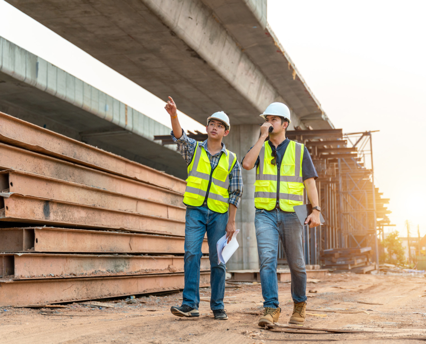 Front view of two construction crew members walking together at site